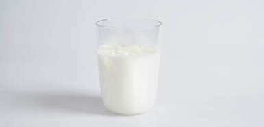 Ein Glas mit Milch mit hellem Hintergrund
