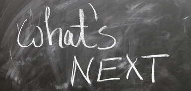 Schriftzug mit Kreide auf einer Tafel: What's NEXT