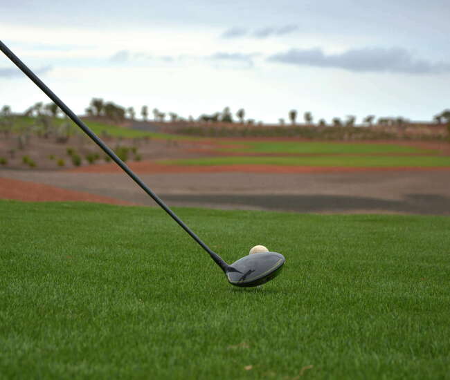 Golfschläger und Golfball auf dem grünen Rasen